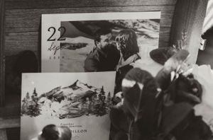 Vintage black and white photographs showing mountain landscapes and scenic views arranged on a wooden surface.