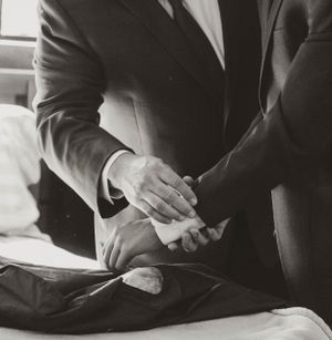 Black and white image of two people in business attire shaking hands during a professional meeting.