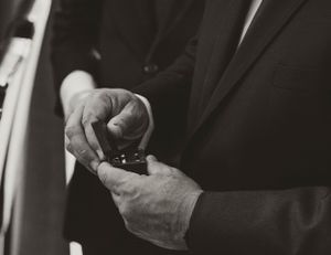 Black and white close-up of hands holding a small box.
