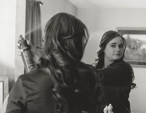 Black and white image showing a reflection in a mirror during preparation.