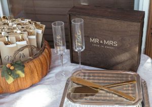 Wedding reception table setup with champagne flutes and a Mr & Mrs wooden sign box on rustic surface.