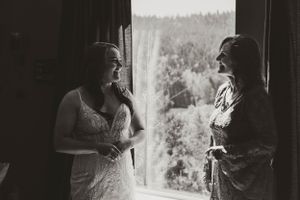 Two silhouettes stand by a window in black and white, creating an intimate moment.