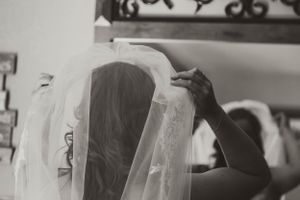 Black and white image showing delicate adjustments being made to a bridal veil.