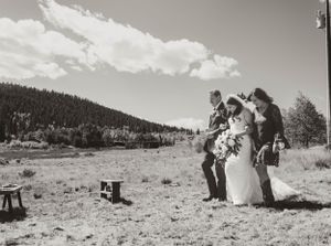 A scenic mountain ceremony setup with wooden stools in a rustic outdoor setting.