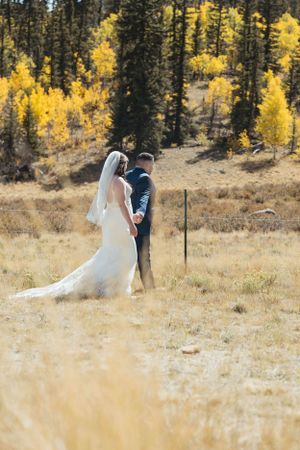 A couple shares an intimate moment against a backdrop of golden aspen trees in the mountains.