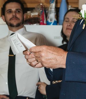 Close-up view of hands holding a document during what appears to be a formal ceremony or signing event.