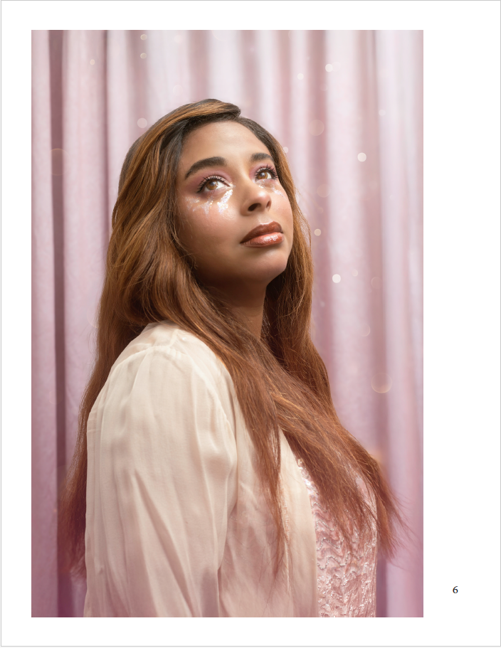 a woman crying glitter in front of a pink backdrop