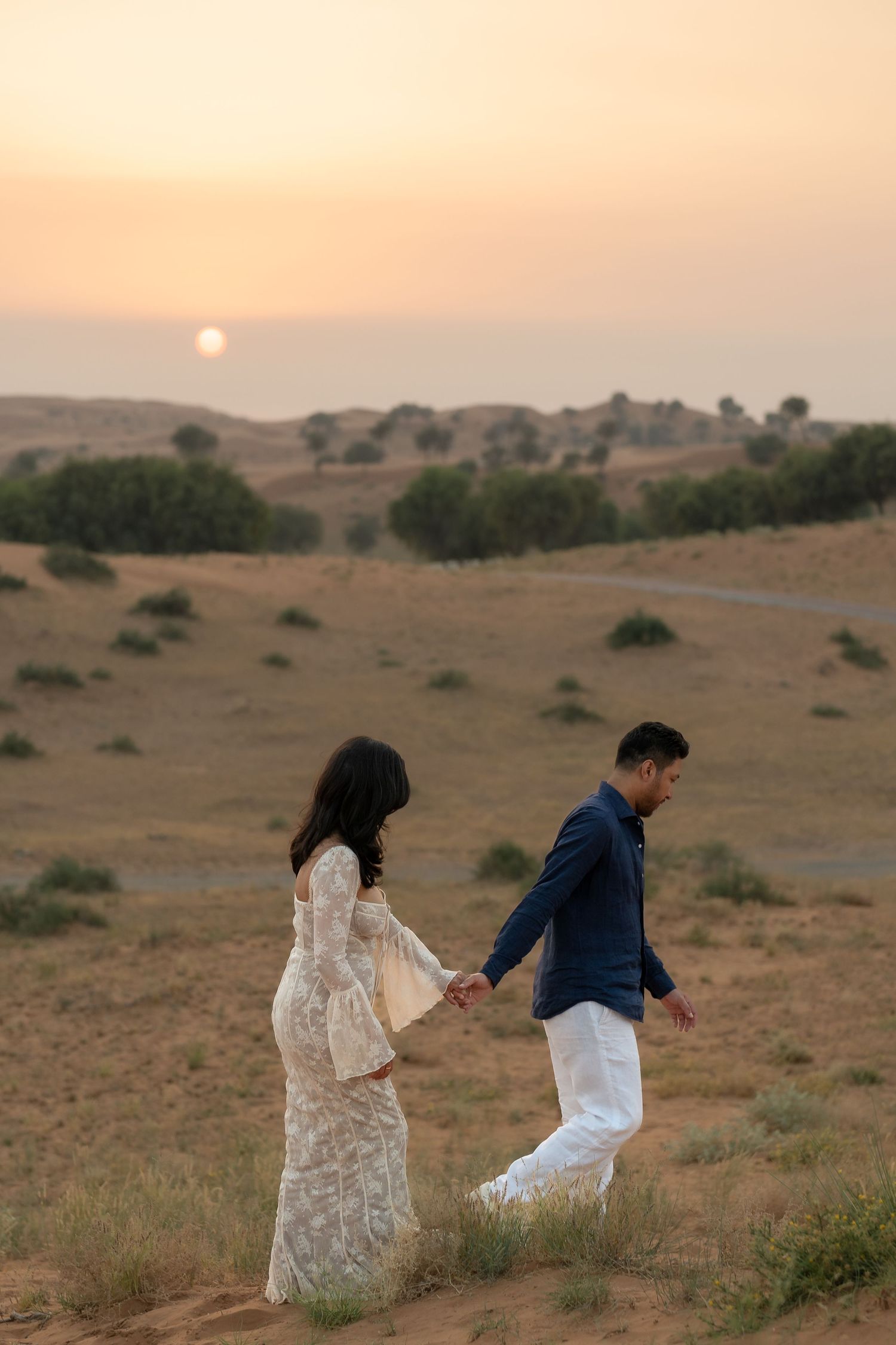 Pre-wedding photoshoot in Dubai desert – couple walking together at sunset