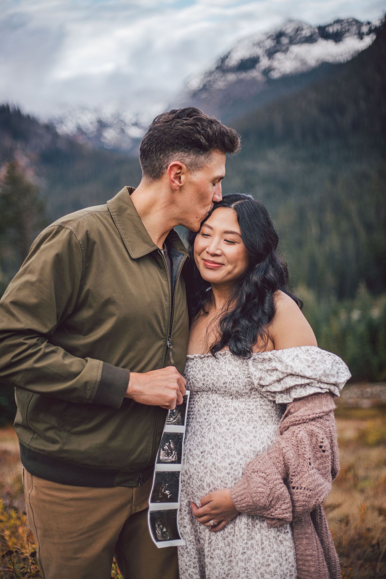 Couple kissing together during their pregnancy announcement and maternity photo shoot in Snoqualmie, Washington
