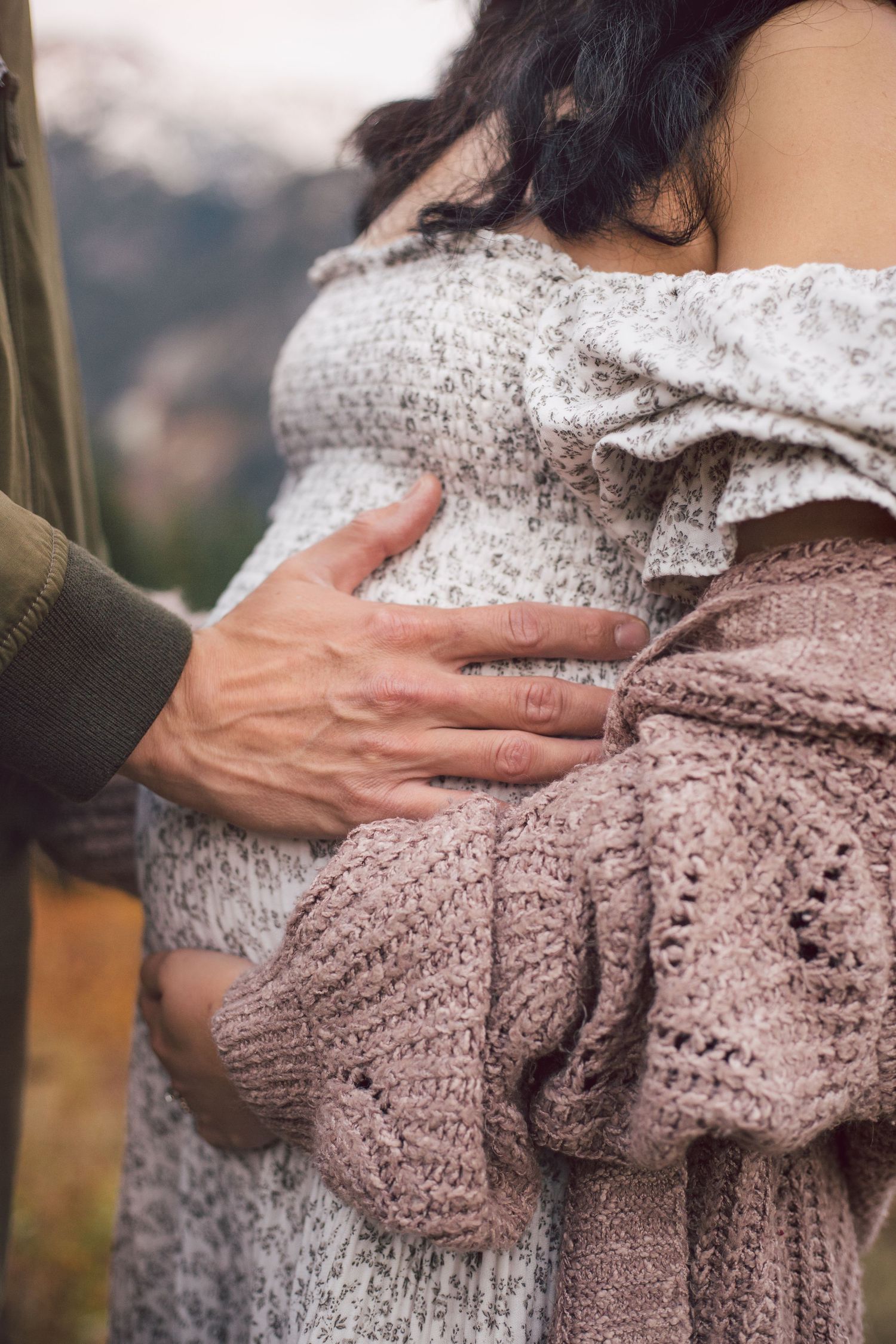 Close-up of baby bump and couple snuggling together during their adventure maternity photoshoot in Snoqualmie, Washington