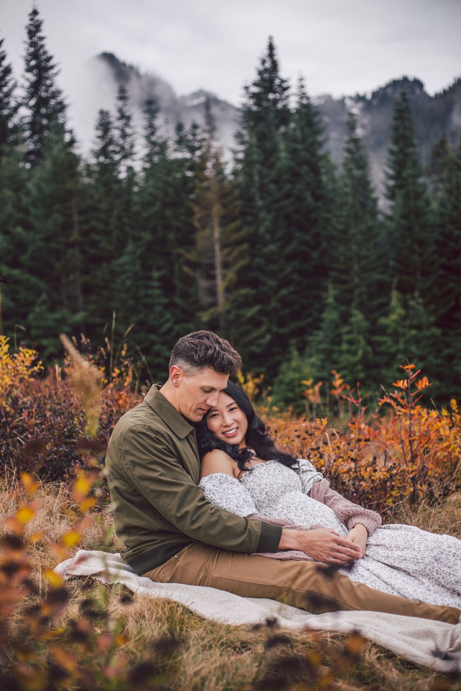 Couple snuggling together during their adventure maternity photos in Snoqualmie, Washington