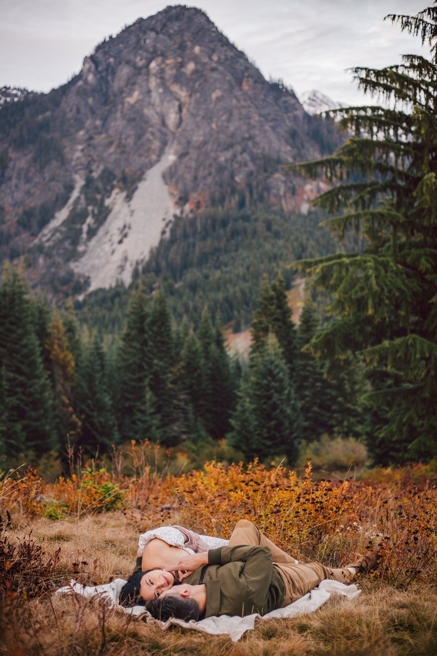 Couple snuggling together during their adventure maternity photos in Snoqualmie, Washington