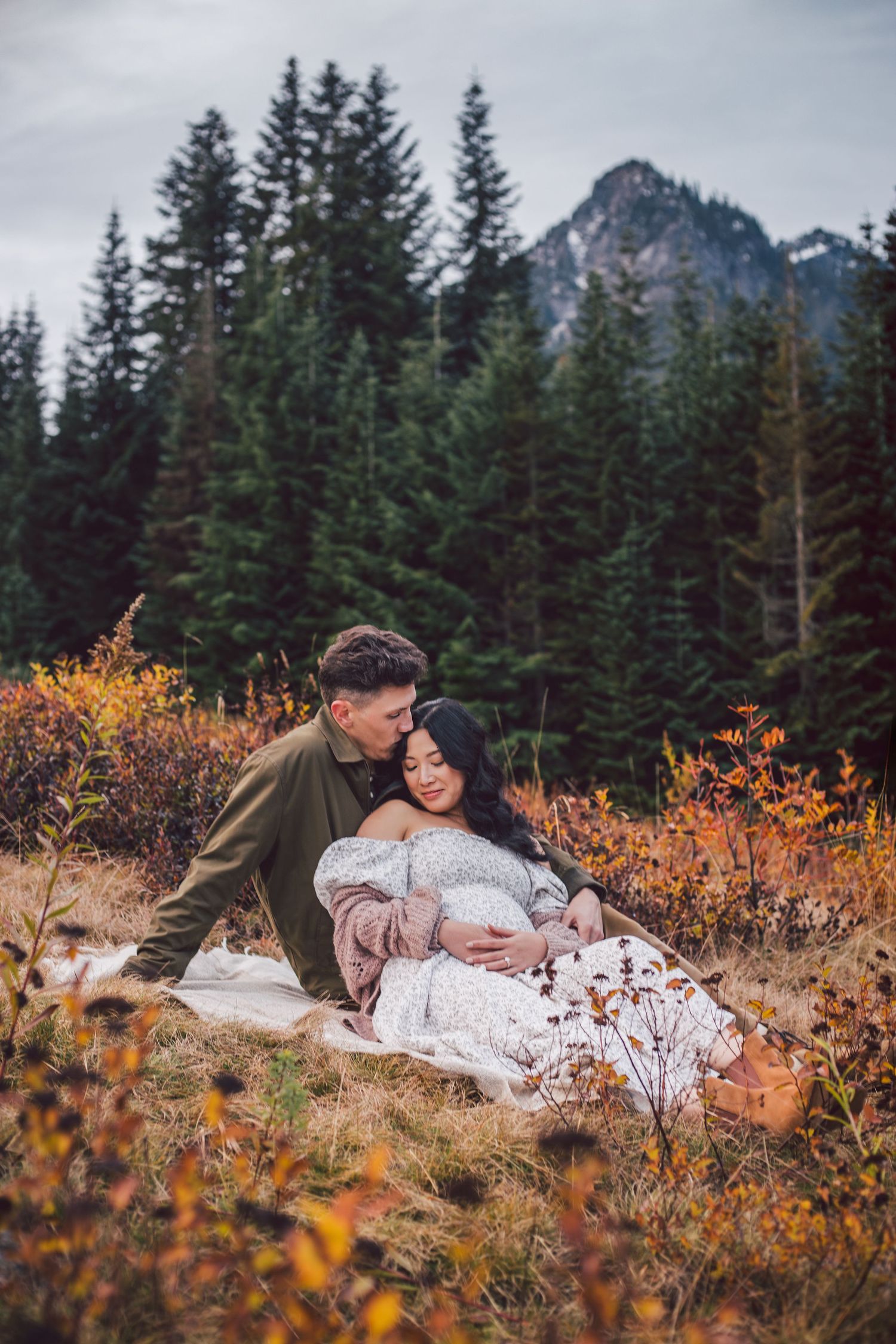 Couple snuggling together during their adventure maternity photos in Snoqualmie, Washington