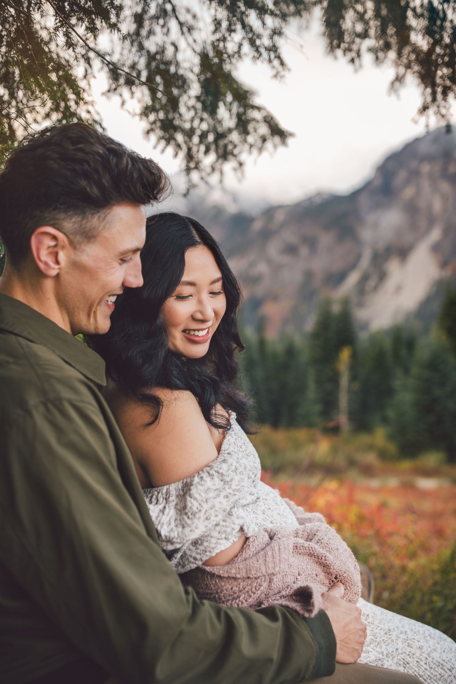 Couple snuggling together during their adventure maternity photos in Snoqualmie, Washington