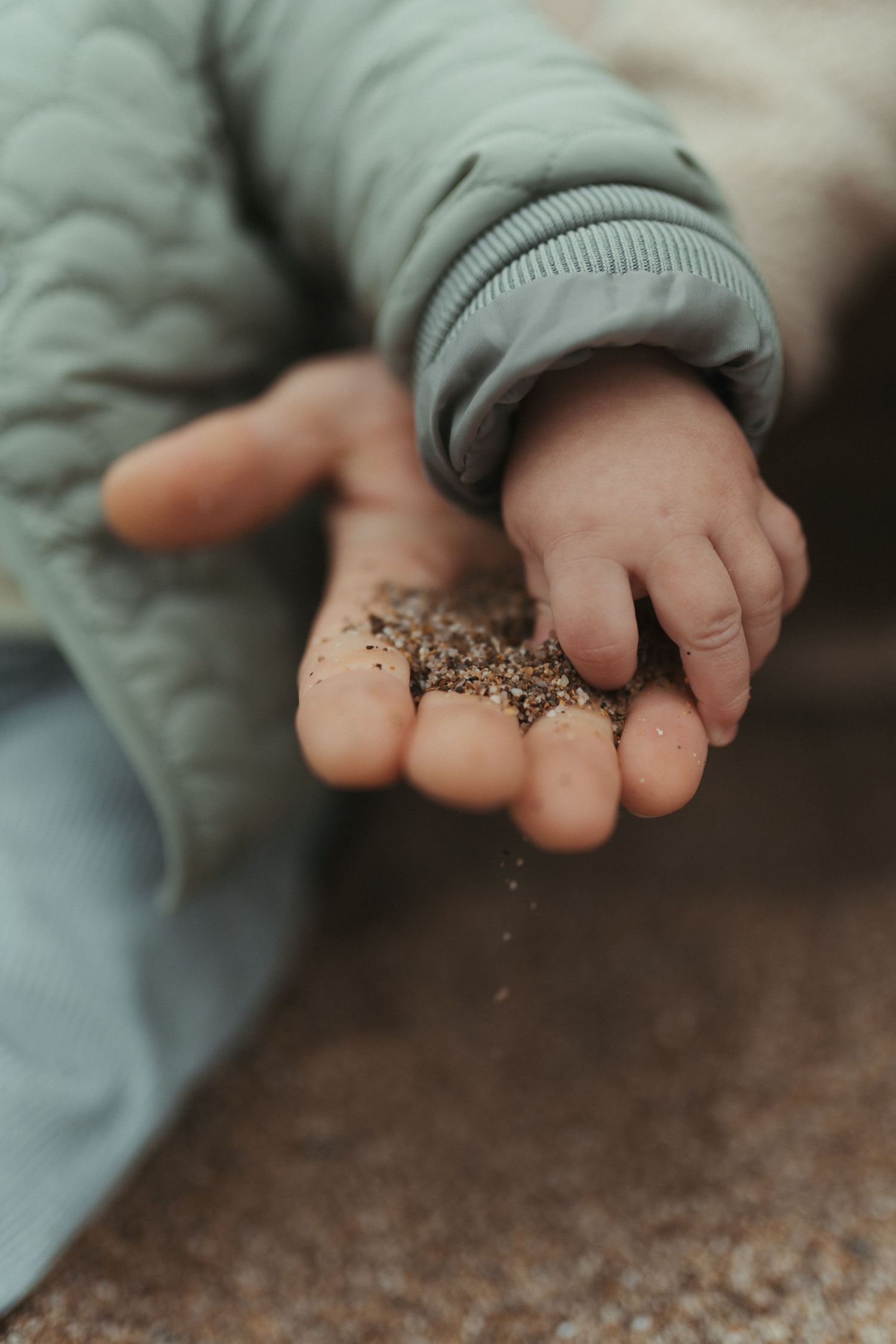 Close-up shots of hands sprinkling small seeds or grains against a dark background.