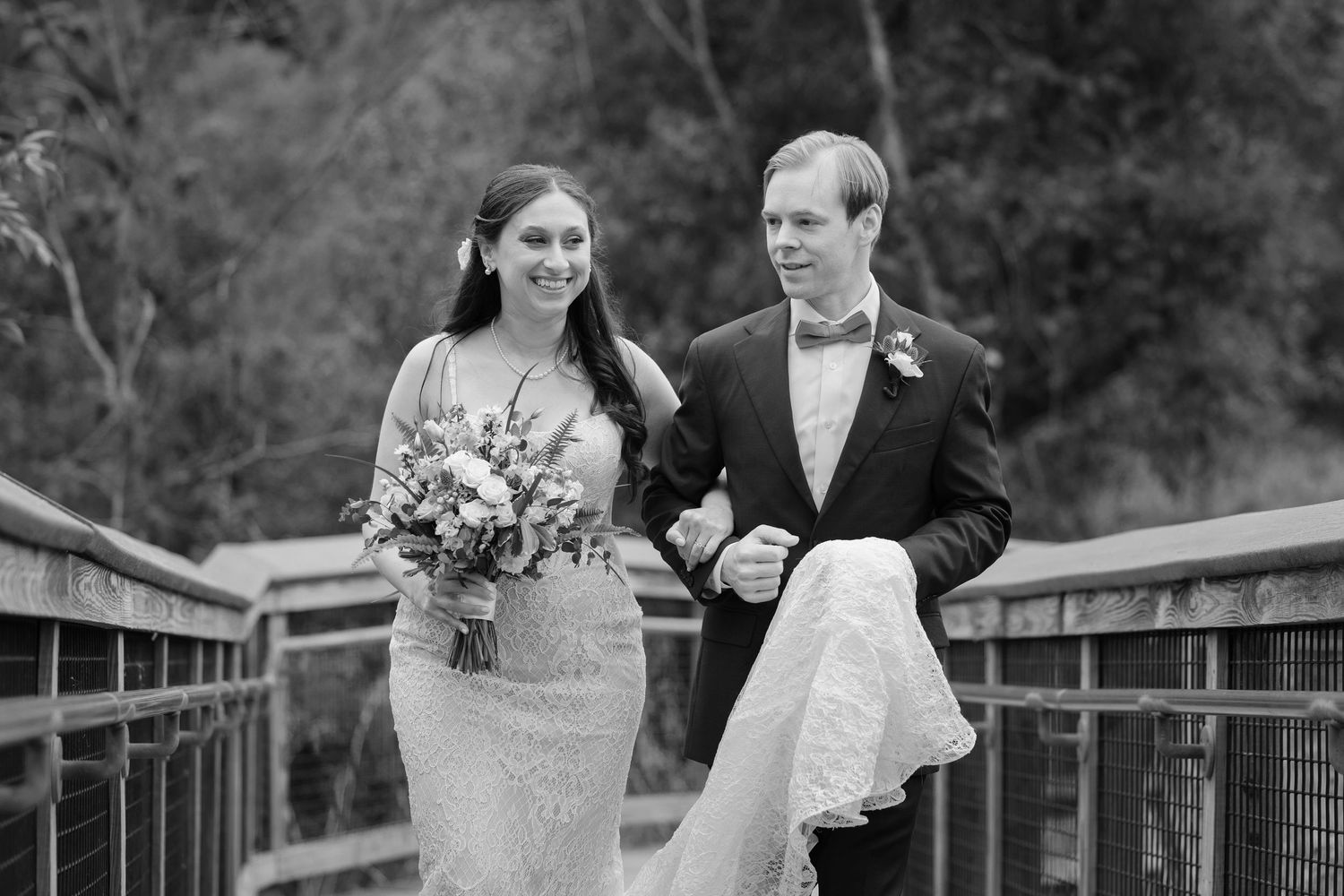 Groom hiding bride's dress while they walk through Shaker Nature Reserve in Cleveland photographed by Tom Forrest.