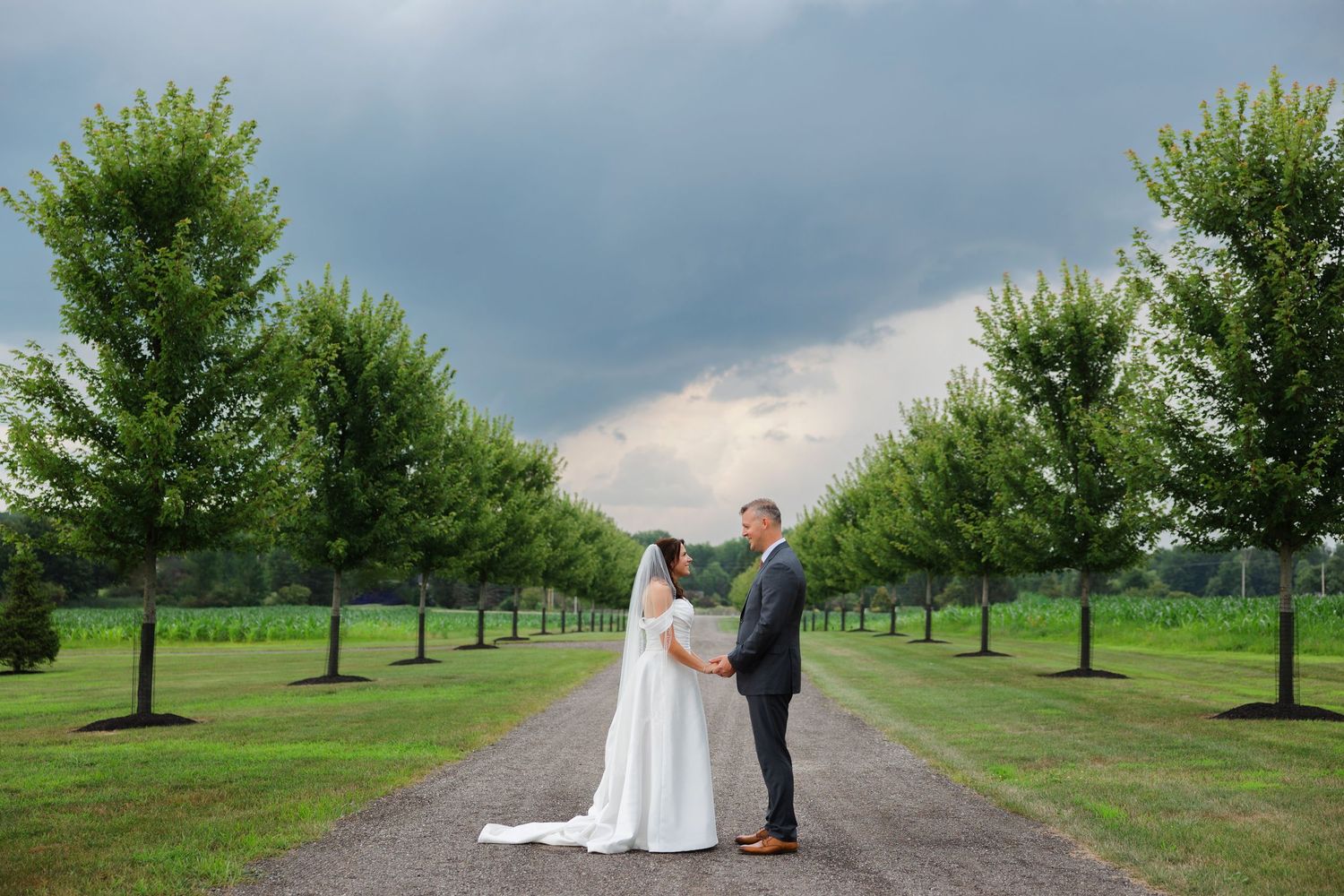 Bride and groom near beautiful tree line during their wedding day at Tall Oaks East photographed by Tom Forrest Photography of Hudson, Ohio.