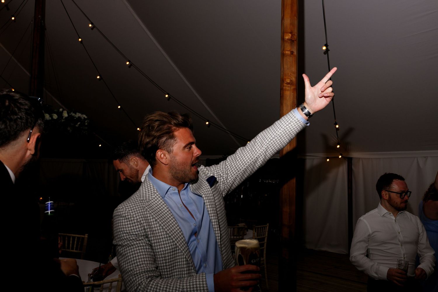 People dancing and enjoying themselves at a dimly lit party or celebration venue.
