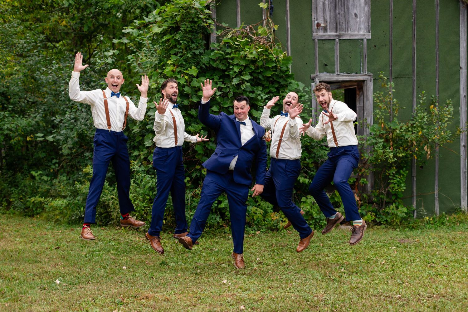 A sequence of joyful jumping poses in front of a rustic barn Duluth Minnesota Wedding Photographer