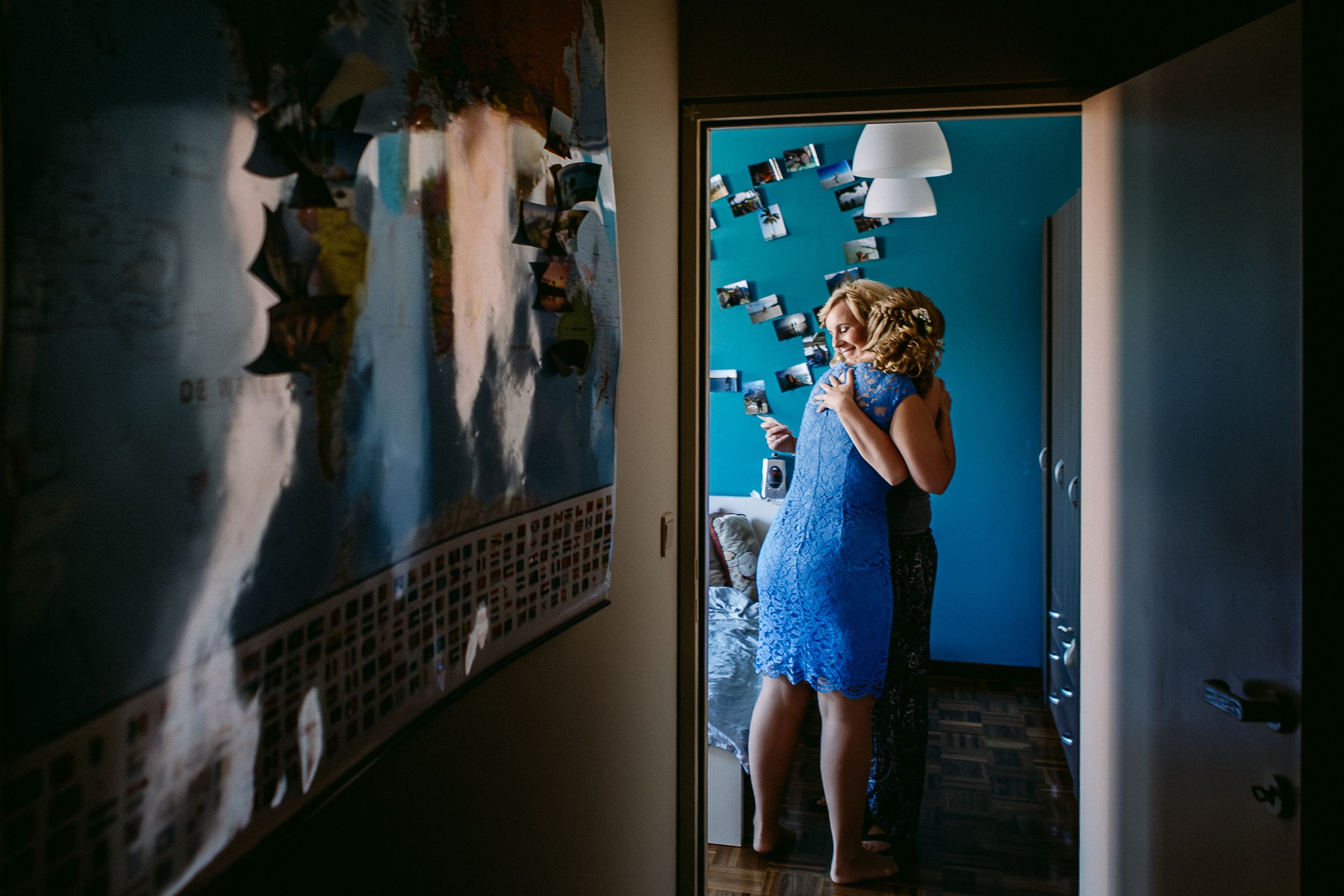 A series of silhouettes and shadows cast on blue walls in a dimly lit hallway.