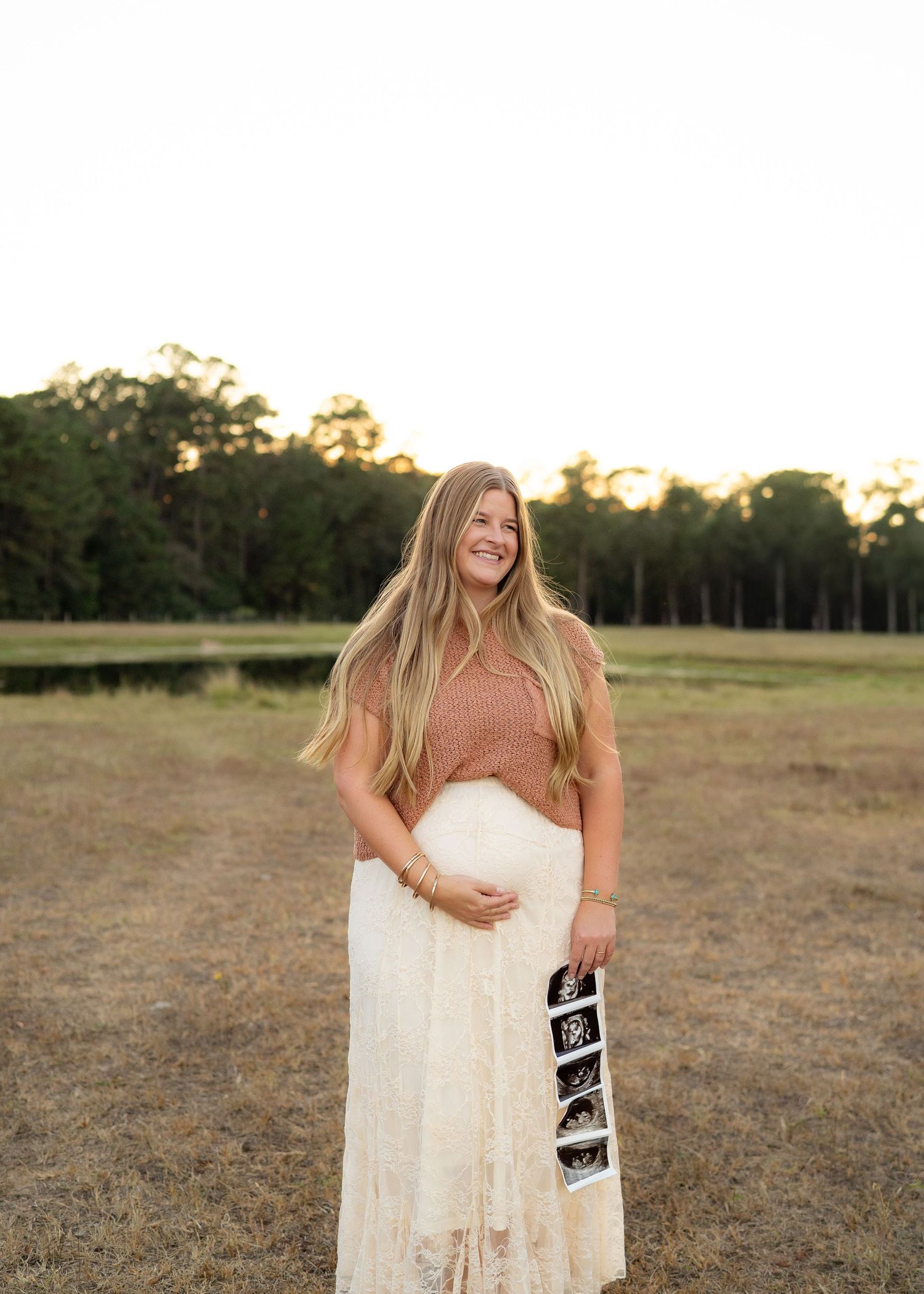 The Emerson family smiling together outdoors during their second baby announcement session.