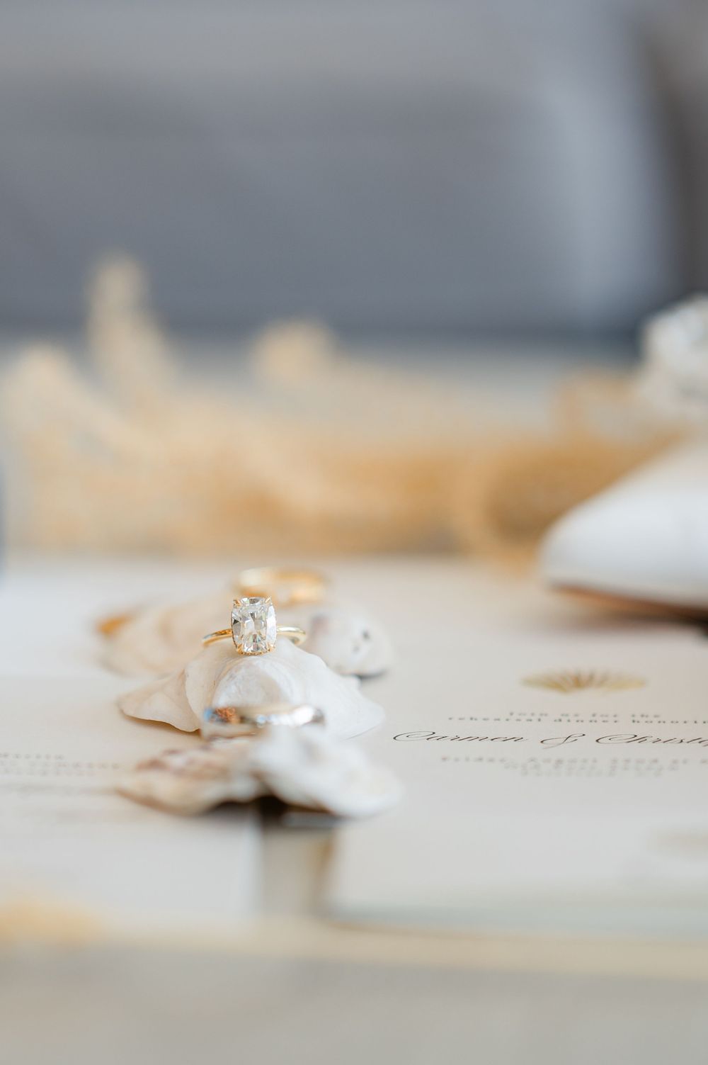 Close-up view of elegant diamond engagement rings on a textured paper surface.