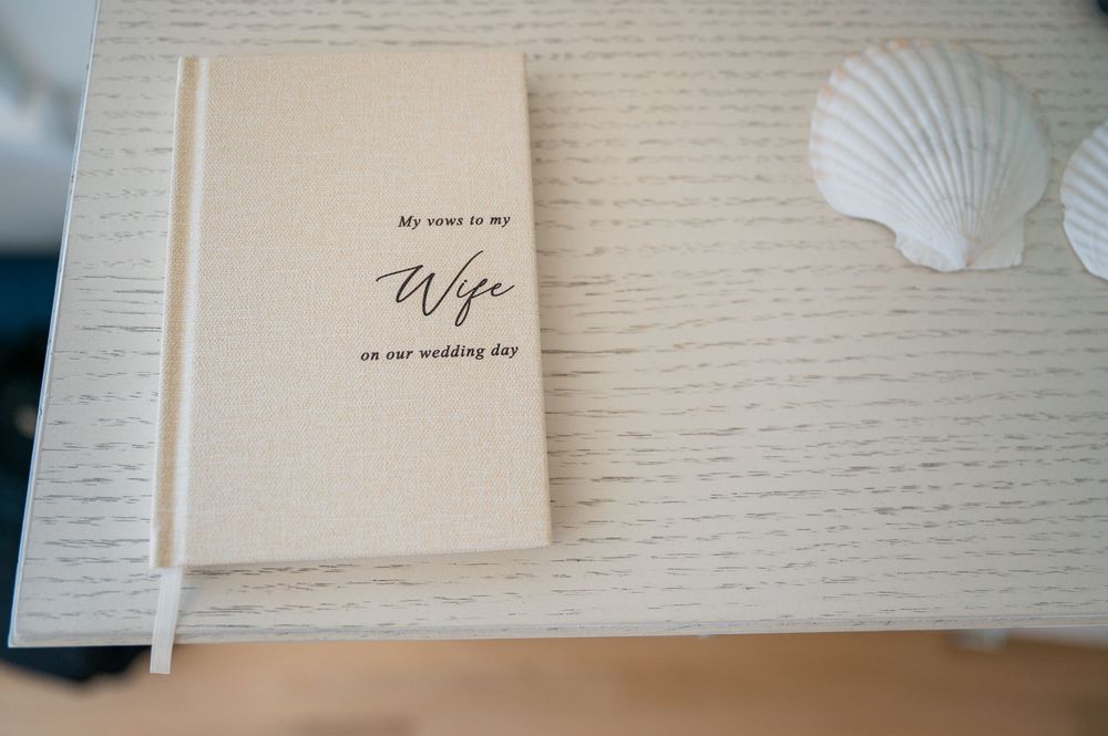 Minimalist white paper wedding invitations arranged in a neat row on a textured surface.
