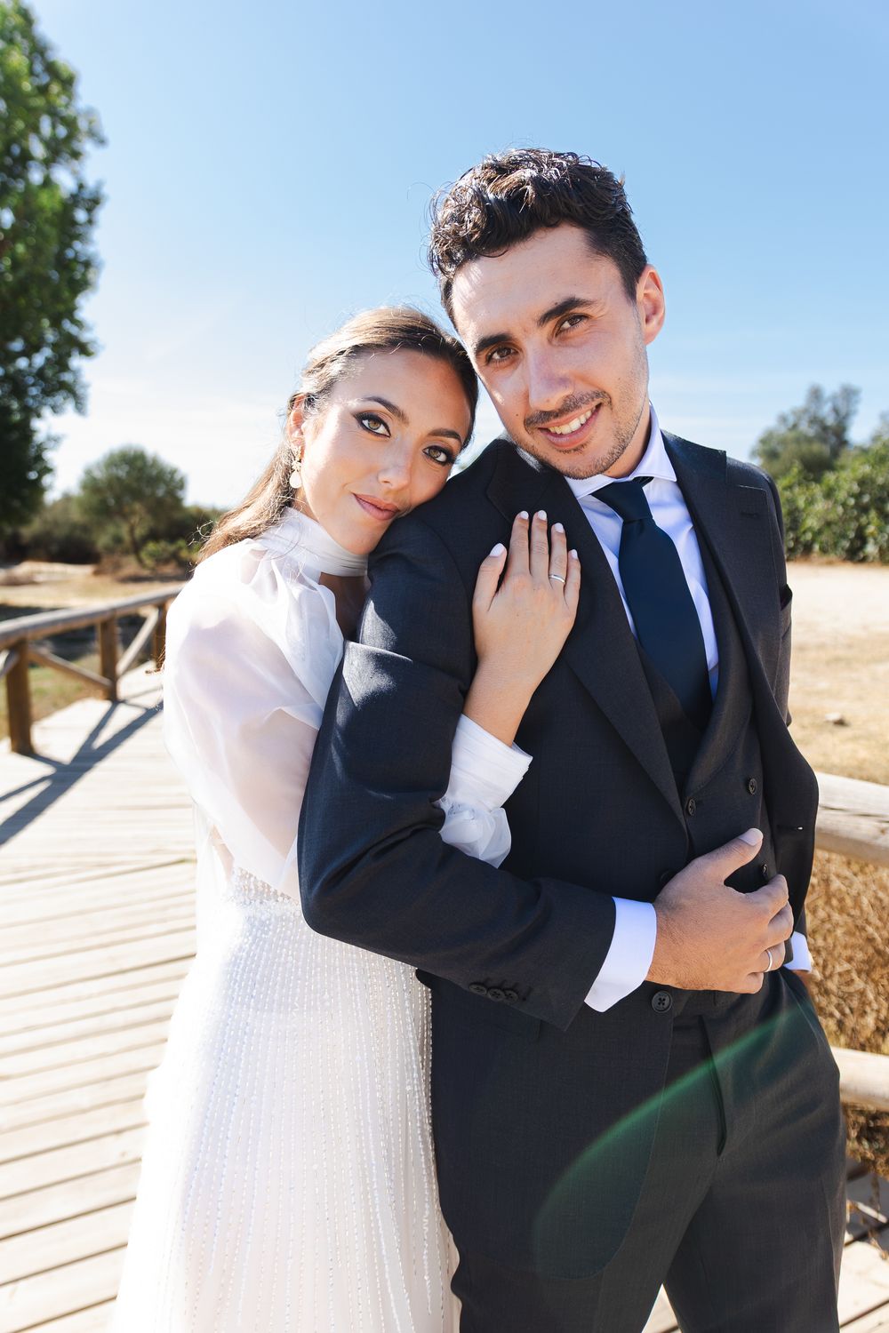 Playful wedding portraits captured outdoors showing affectionate moments between newlyweds.