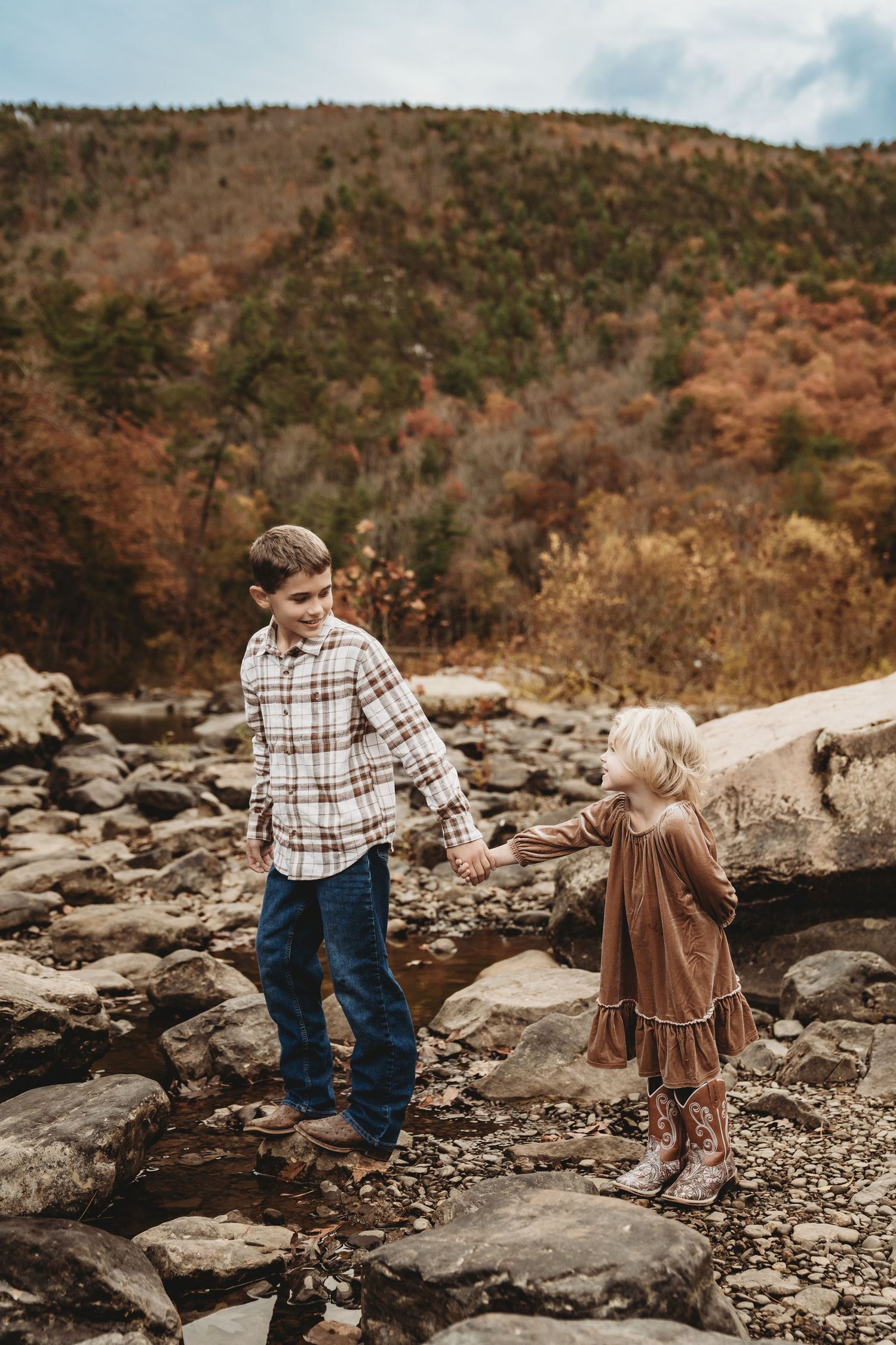 Couple exploring rocky terrain during autumn in the mountains.