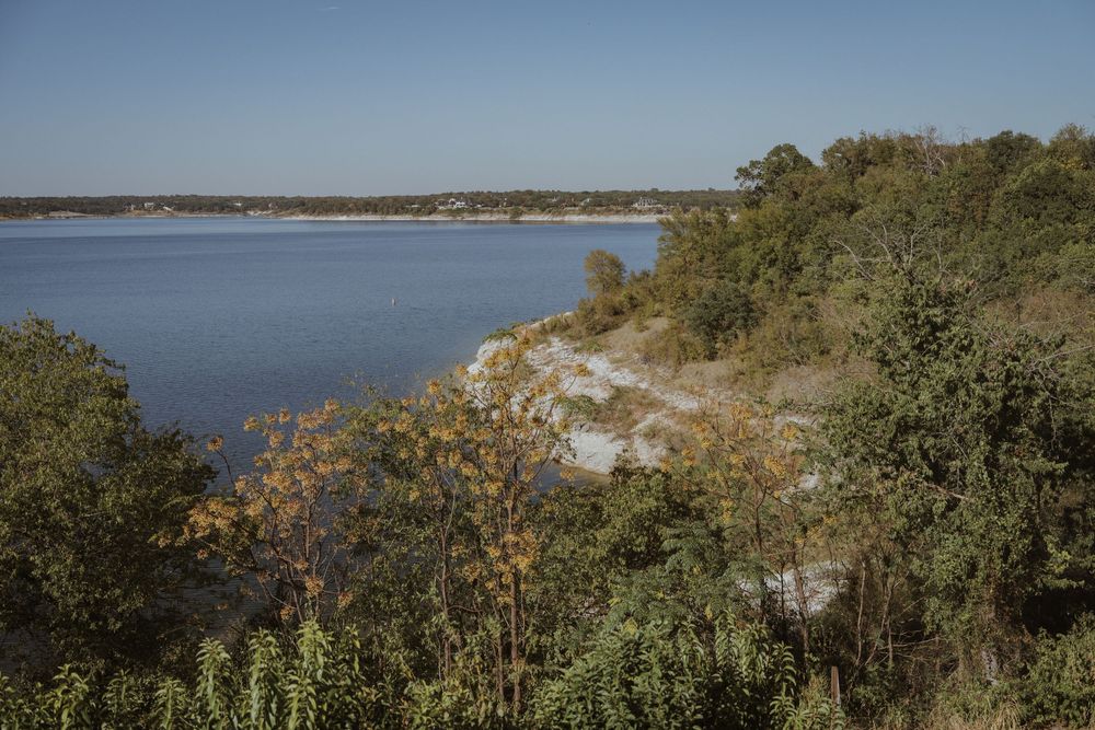 Scenic coastal landscape with autumn trees and water views on a clear day.