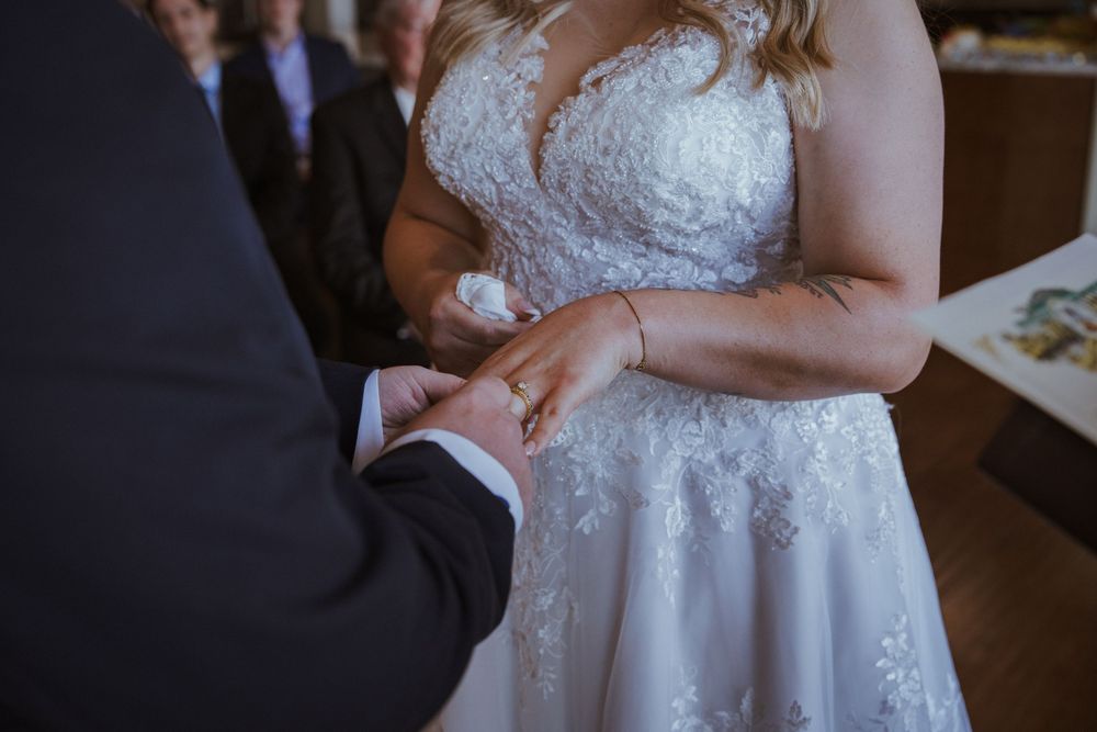 Close-up details of an elegant white lace wedding dress with sparkle embellishments.