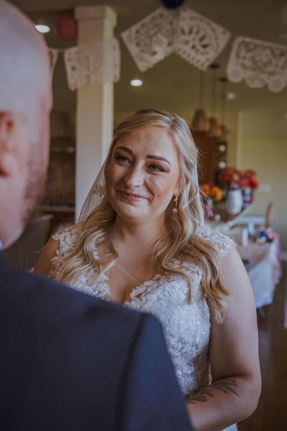 Romantic wedding moment captured under decorative white lace bunting.