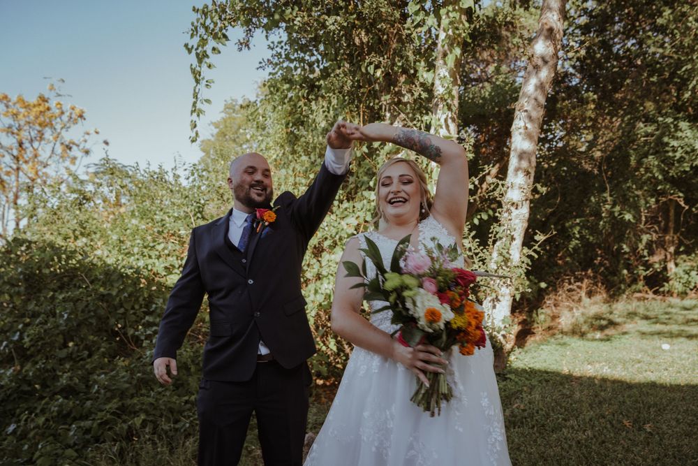 Wedding couple shares a playful dance moment on their special day by the ocean.
