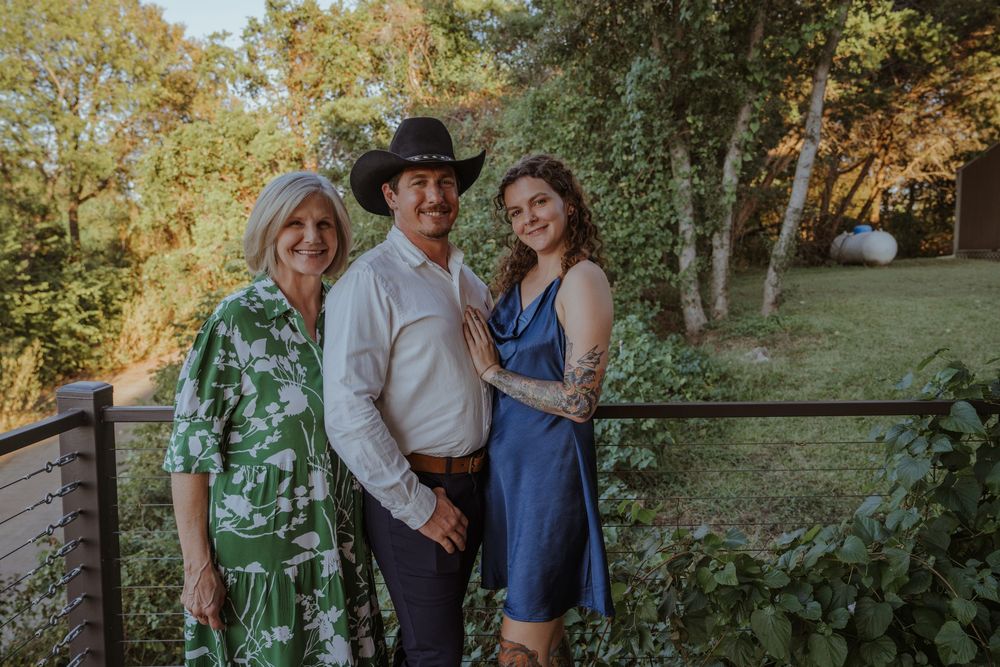 Outdoor family gathering in a natural setting with trees and greenery.