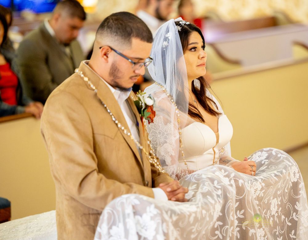 A couple sits during their wedding ceremony in a church.