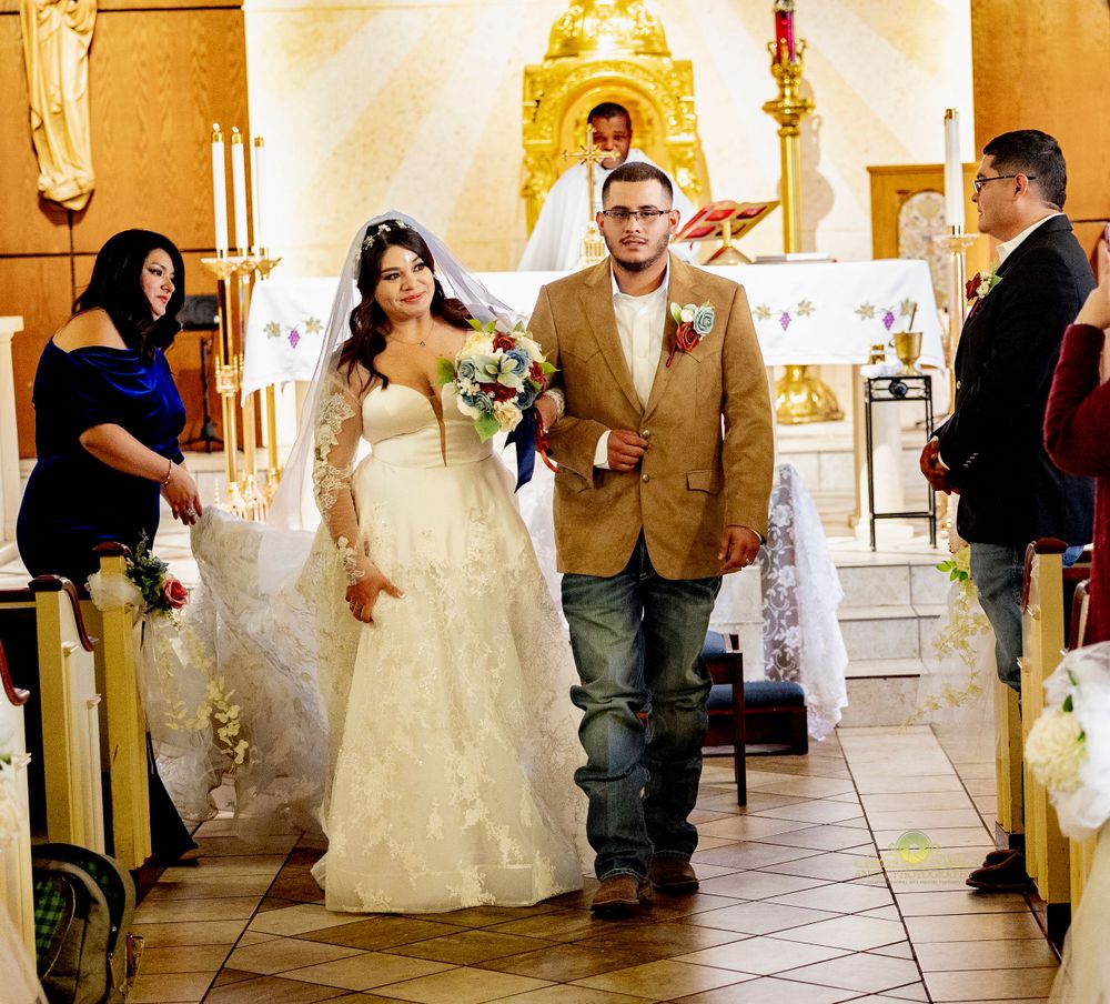A wedding ceremony procession in a church with decorative candles and altar.
