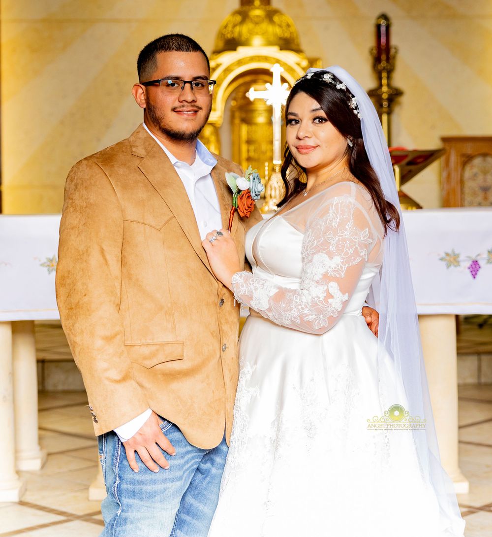 A wedding couple poses in front of a church altar with golden decor.