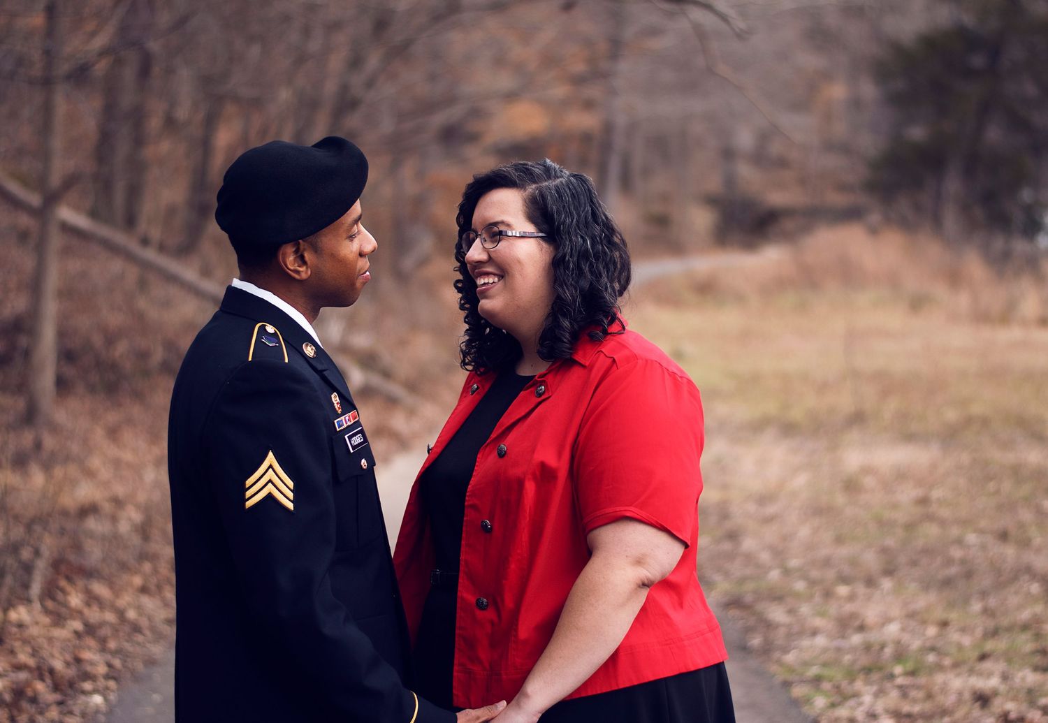A couple shares an emotional moment, one wearing military uniform.