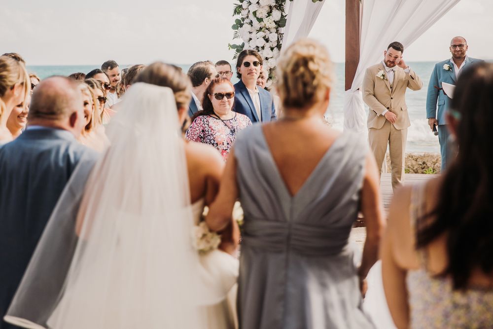 Wedding guests dance and celebrate together under an elegant white tent during an outdoor reception celebration. El Dorado Royale Wedding