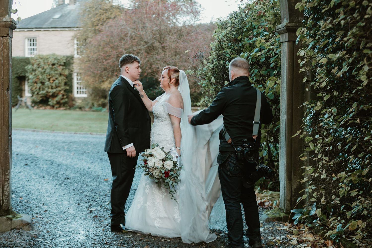 A couple shares a joyful moment with an officiant during their outdoor winter wedding ceremony.