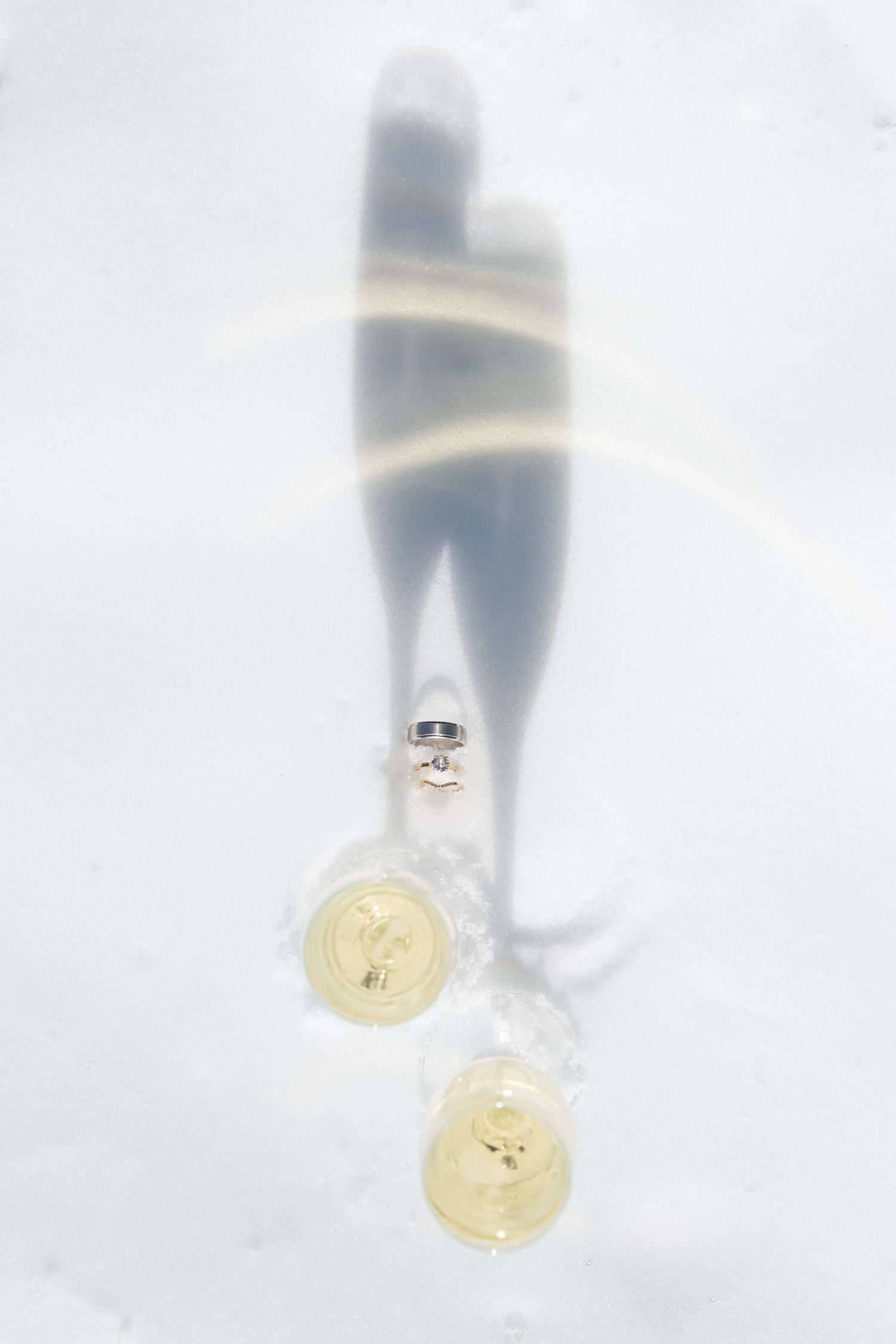 A gold coin partially submerged in snow with blurred background creating an artistic winter composition for Vail Colorado winter wedding