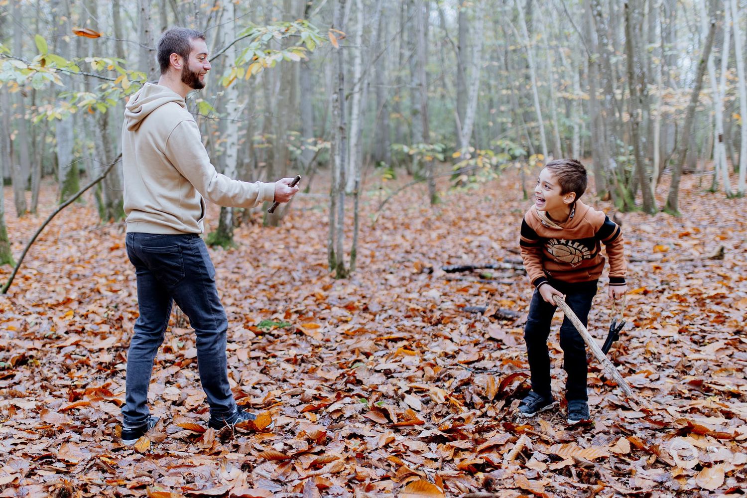 père et fils qui jouent dans la forêt