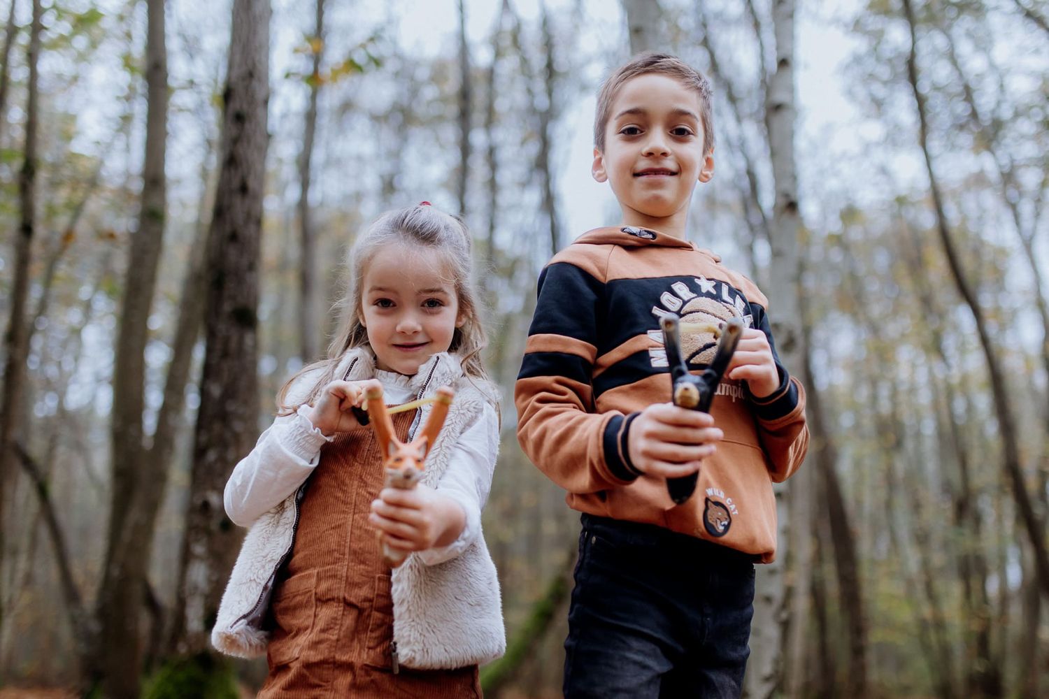 Enfants qui jouent au lance-pierre dans la forêt