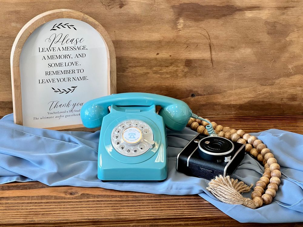 a blue rotary phone and polaroid camera