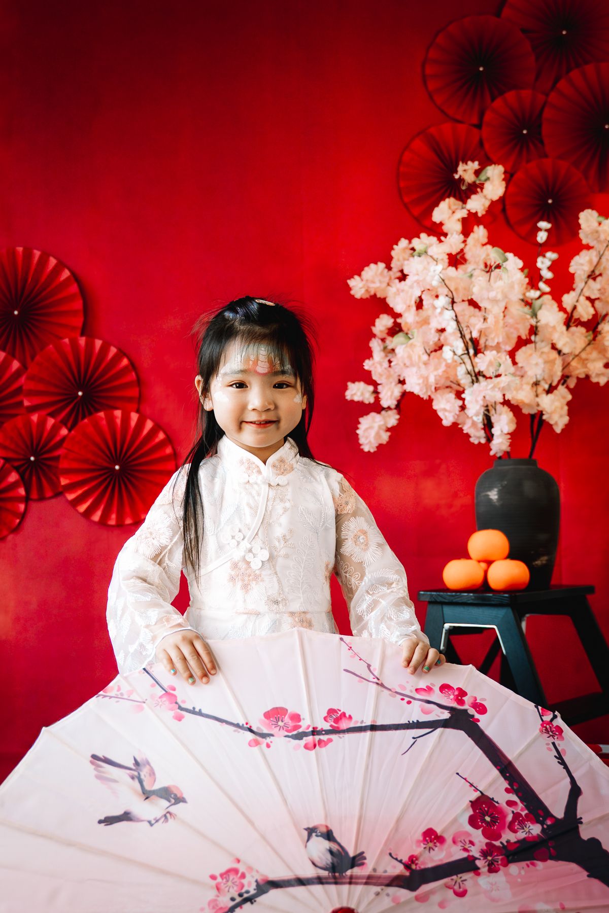 A portrait of a girl in Chinese costume, red backdrop and Lunar new year prop taken at a Melbourne Lunar new year mini session.