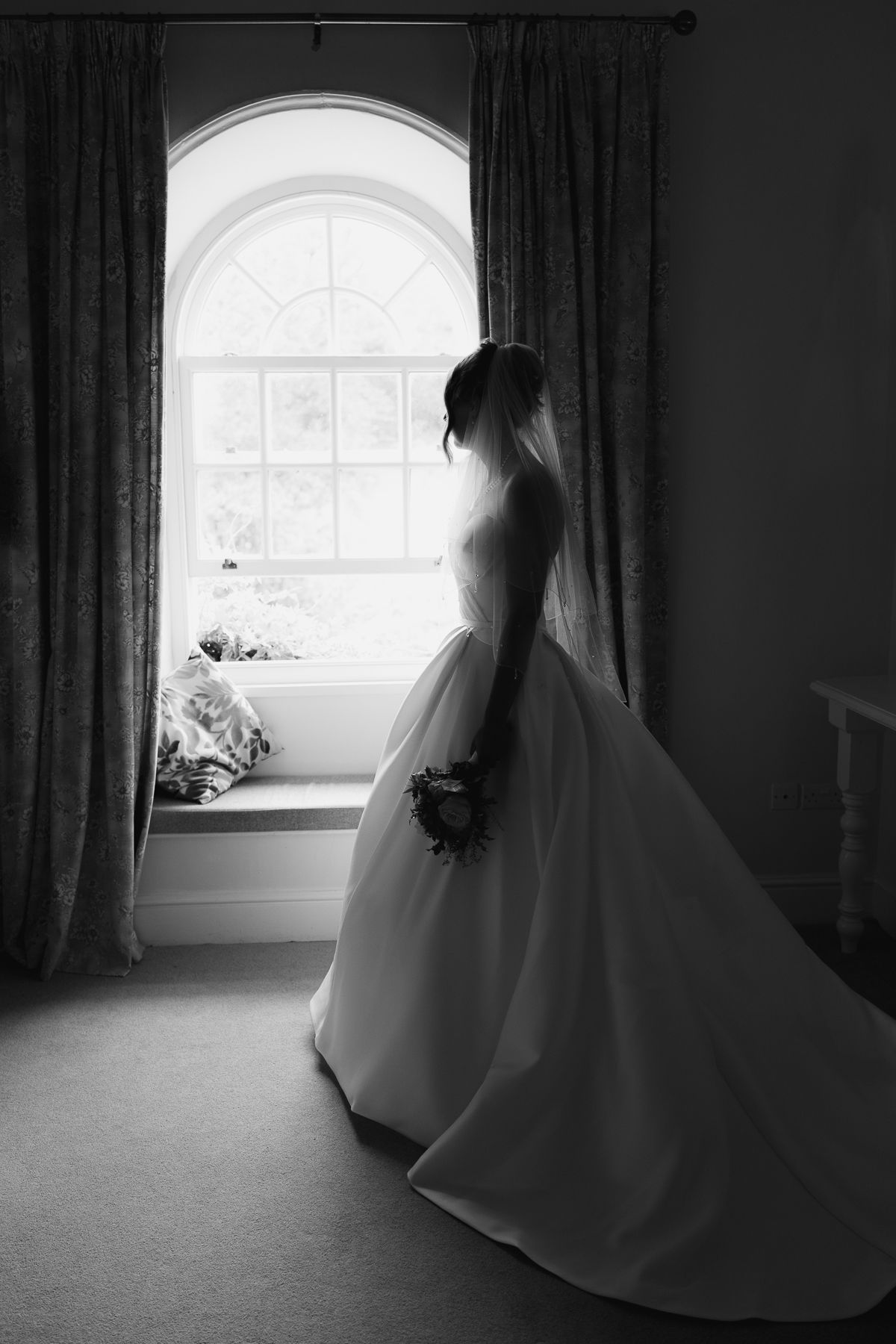 A series of moody black and white photographs showing a figure in white near a window with dramatic lighting and curtains.