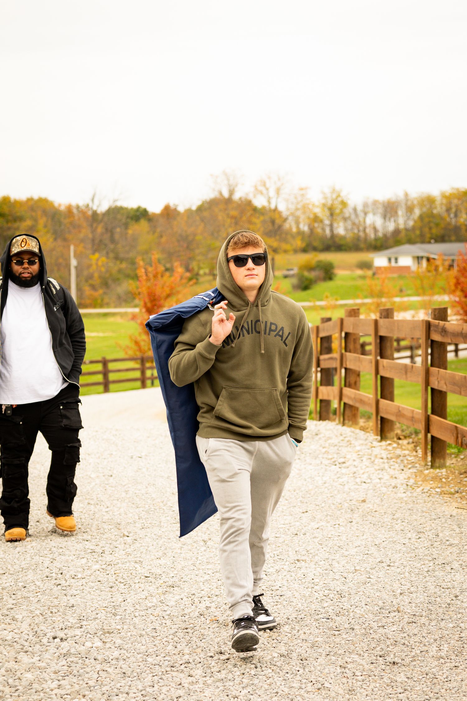 Three sequential photos show a person in casual attire demonstrating a dance move on a gravel path in autumn.