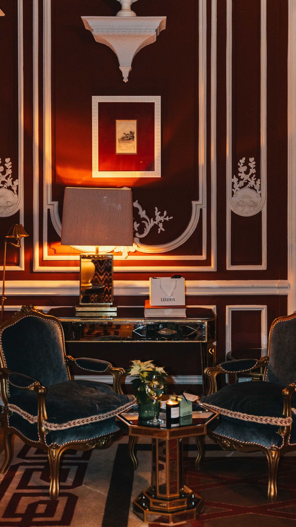 Zona de estar con sillones y mesa central en interior clásico decorado