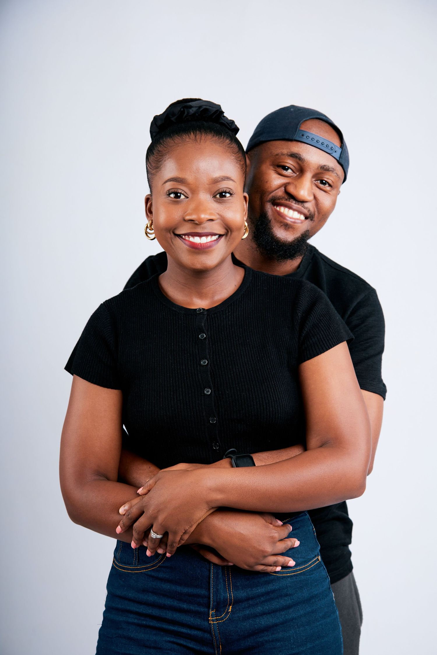 Romantic couple portrait session in matching white outfits against bright background.
