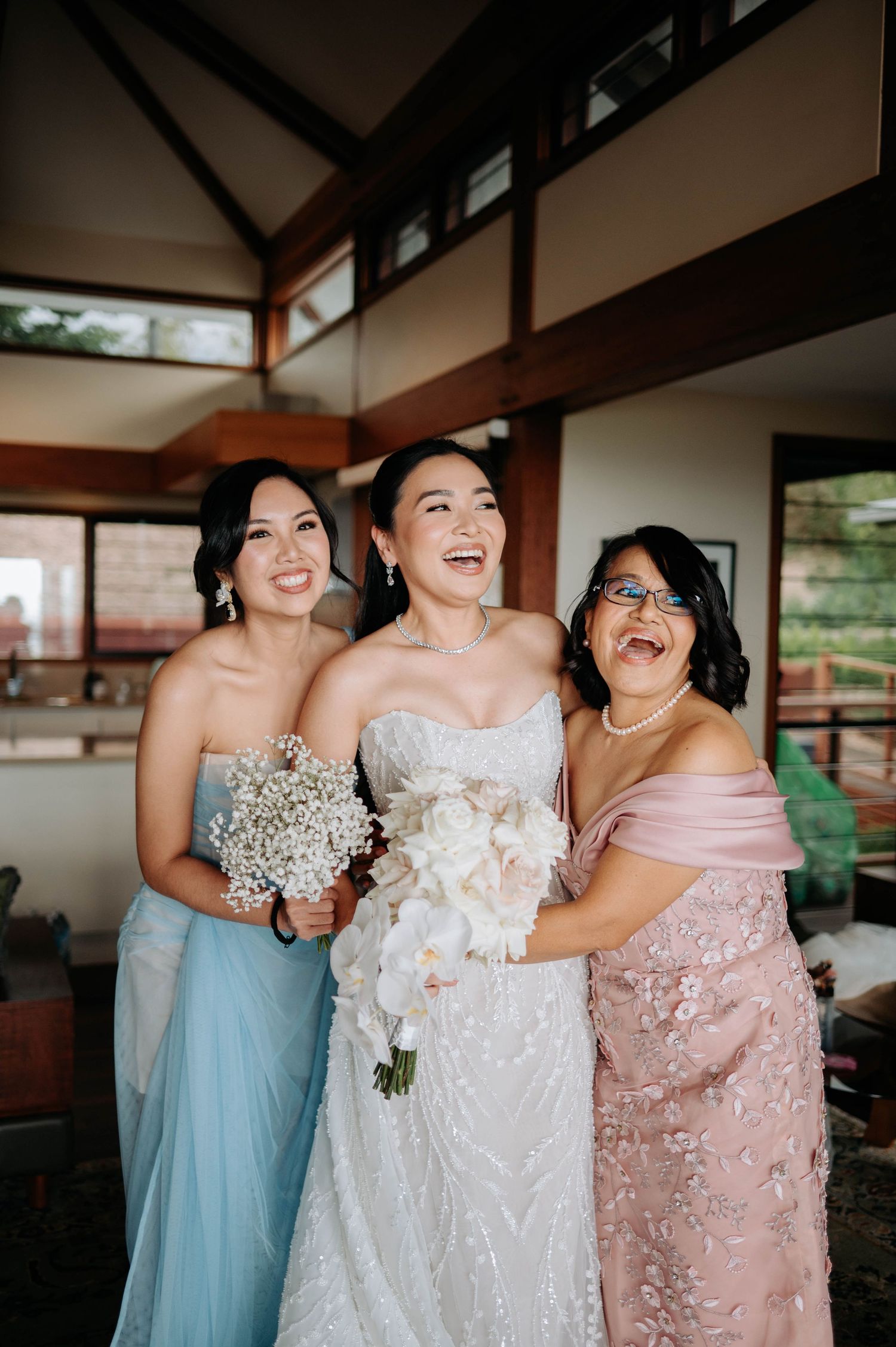 Joyful bridal party sharing a candid laughing moment in formal dresses.